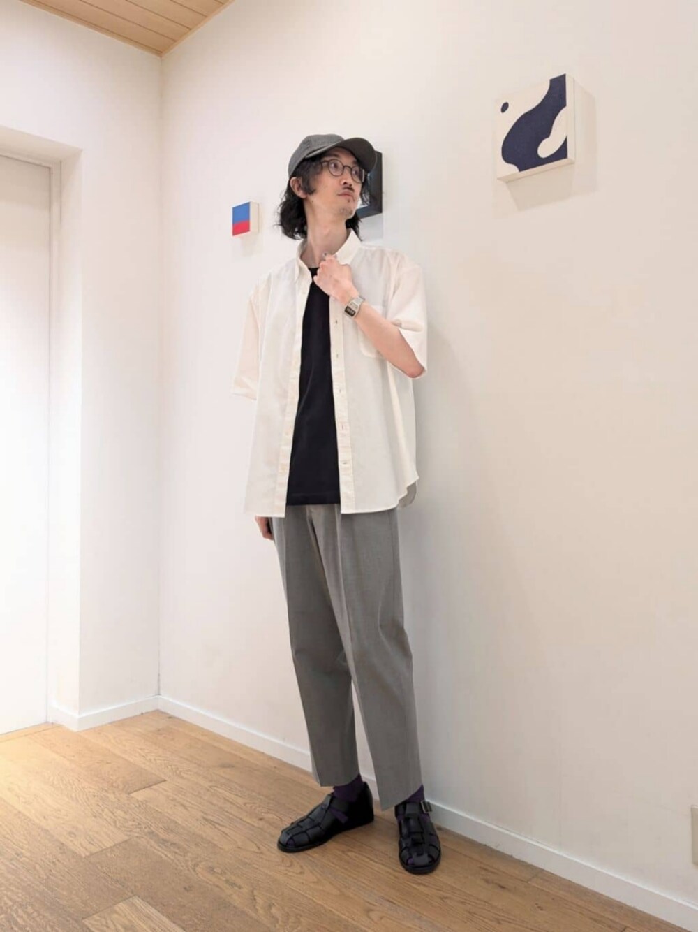ブラック系のTシャツ/カットソー、ブラック系のサンダル、グレー系のスラックスを着用したメンズの夏コーディネートの1枚目の写真