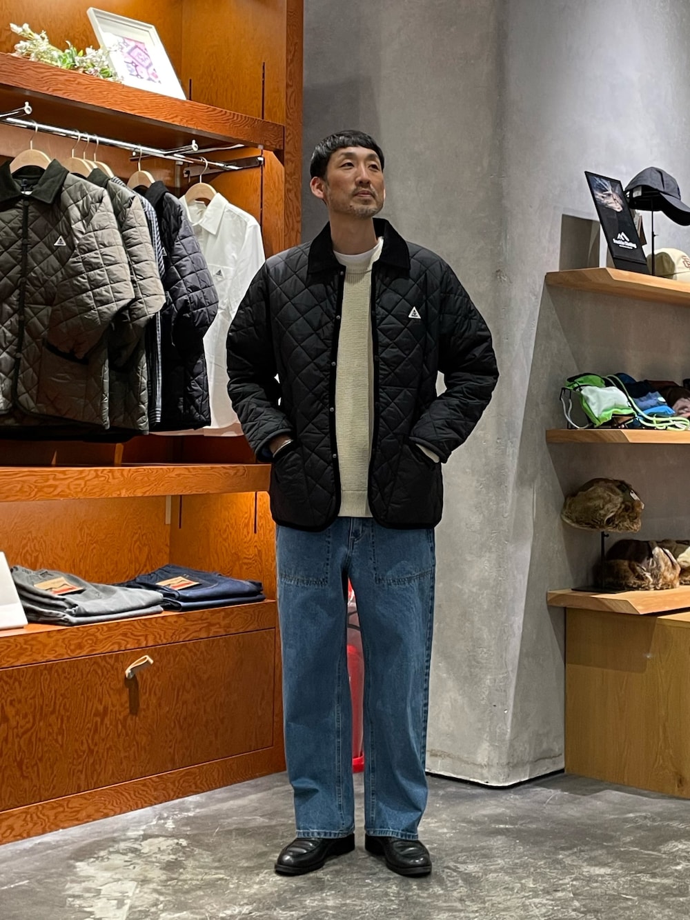 ホワイト系のニット/セーター、ブラック系のブルゾン、ブルー系のデニムパンツを着用したメンズの冬コーディネートの1枚目の写真