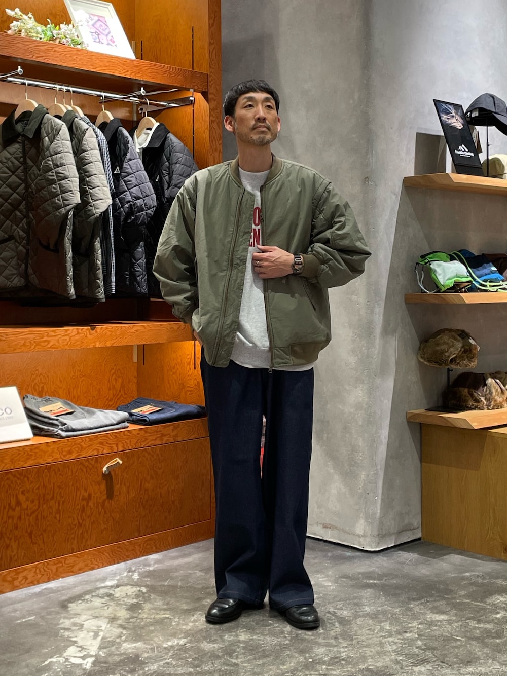 ブルー系のデニムパンツ、グレー系のスウェット、ブラック系のMA-1を着用したメンズの秋コーディネートの1枚目の写真