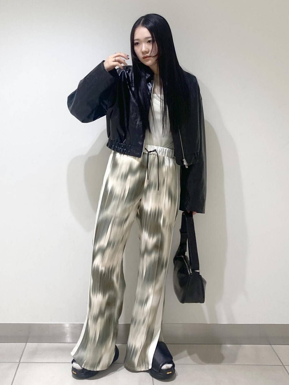 ベージュ系のその他パンツ、ブラック系のサンダル、ブラック系のブルゾンを着用したレディースの春コーディネートの1枚目の写真