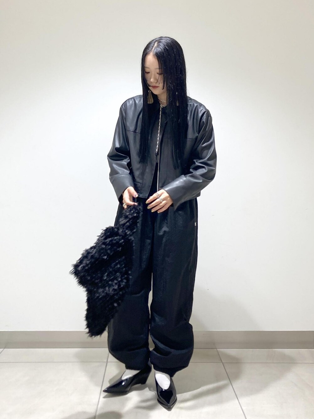 ブラック系のブルゾン、ブラック系のパンプス、ブラック系のハンドバッグを着用したレディースの秋コーディネートの1枚目の写真