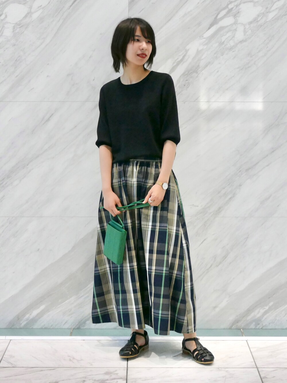 ブラック系のサンダル、グリーン系のショルダーバッグ、ブラック系のニット/セーターを着用したレディースの夏コーディネートの1枚目の写真