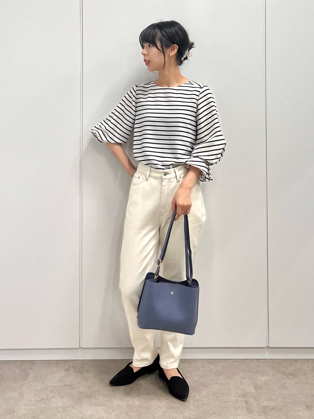 ブラック系のシャツ/ブラウス、ブルー系のショルダーバッグ、ホワイト系のデニムパンツを着用したレディースの秋コーディネートの1枚目の写真