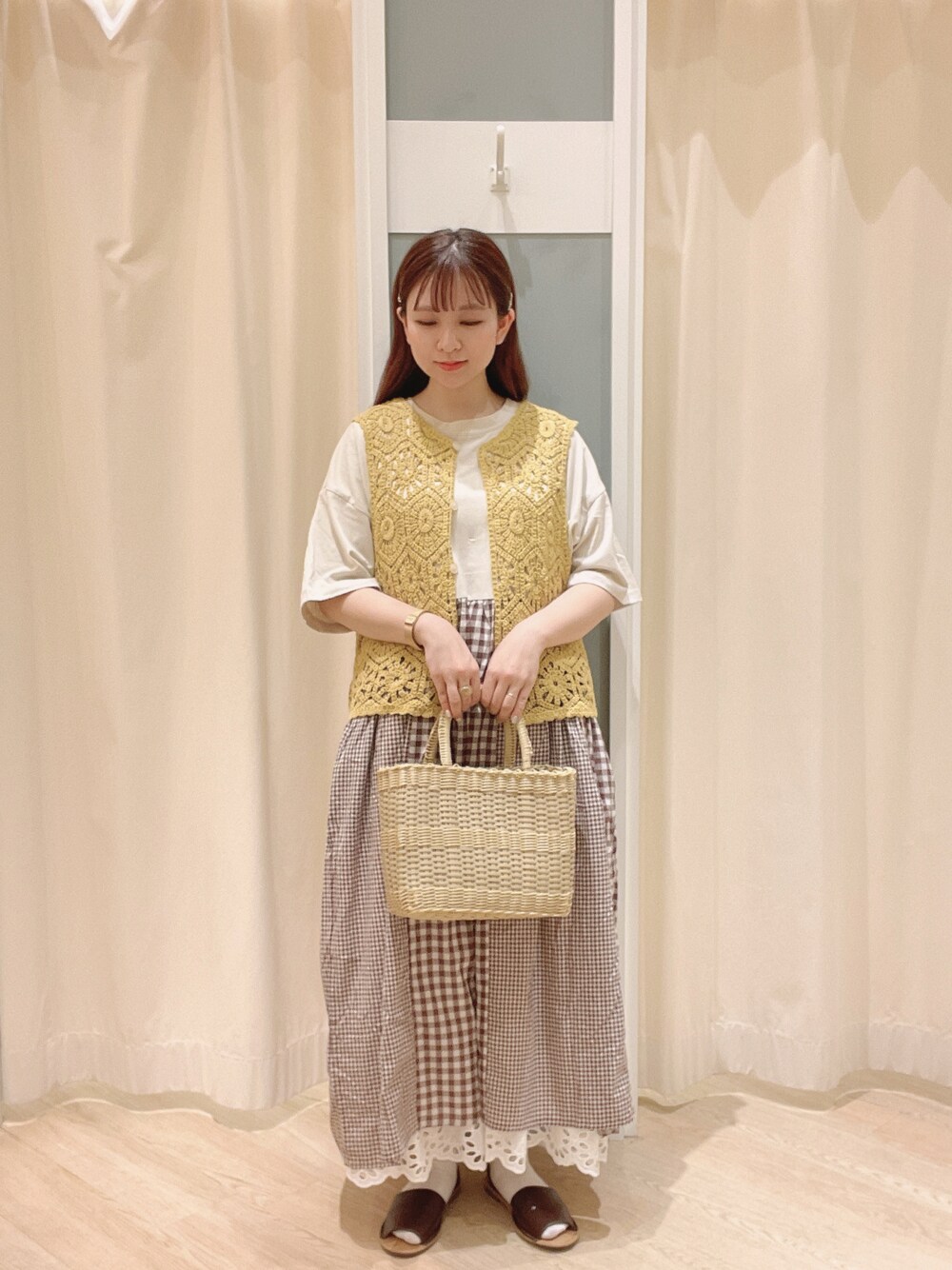 ベージュ系のトートバッグ、ブラウン系のサンダル、ホワイト系のスカートを着用したレディースの夏コーディネートの1枚目の写真