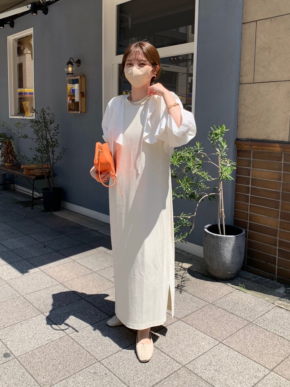 ホワイト系のシャツ/ブラウス、ホワイト系のワンピース、オレンジ系のショルダーバッグを着用したレディースの春コーディネートの1枚目の写真