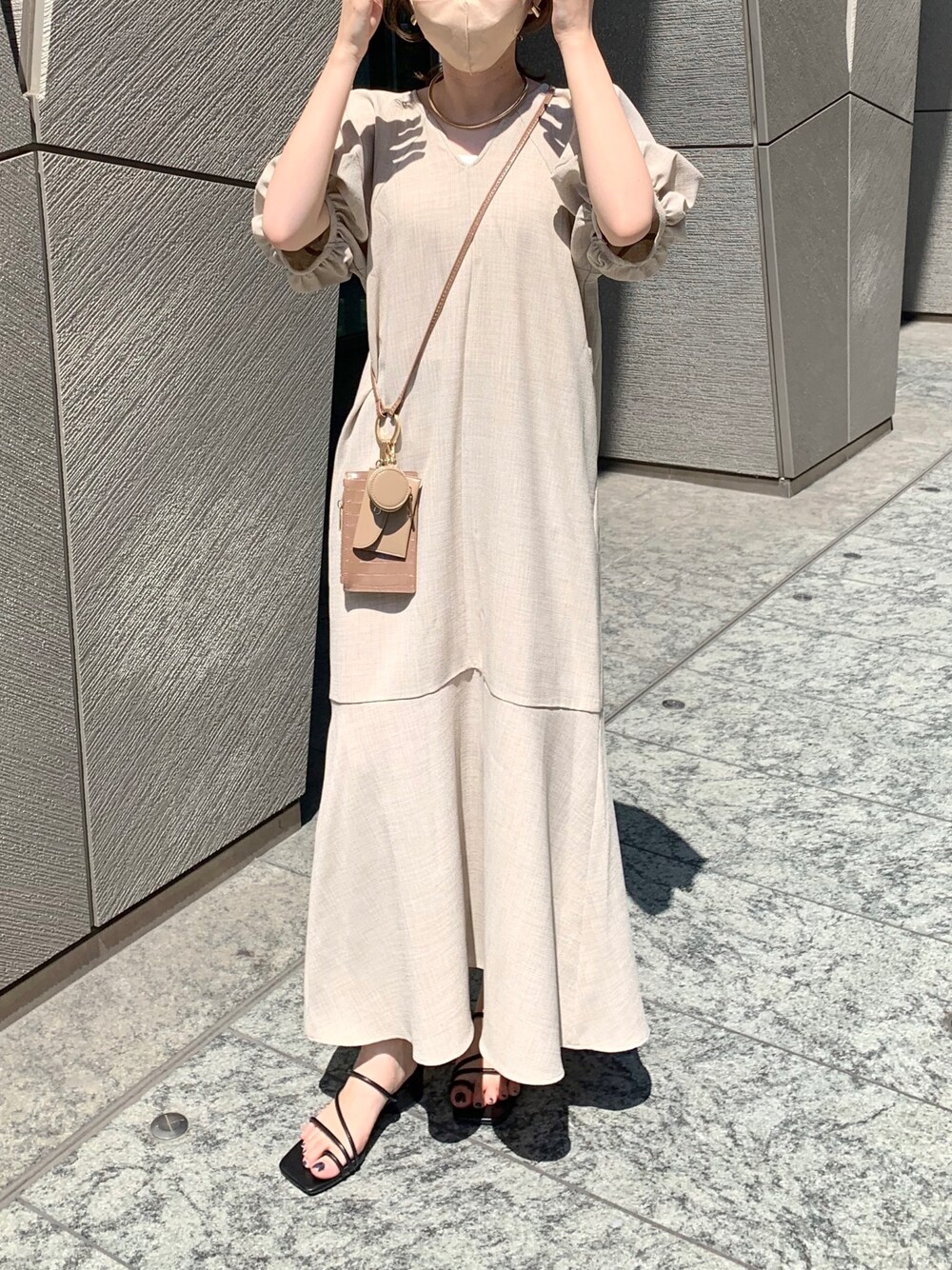 ベージュ系のワンピース、ブラウン系のショルダーバッグ、ブラック系のサンダルを着用したレディースの夏コーディネートの2枚目の写真