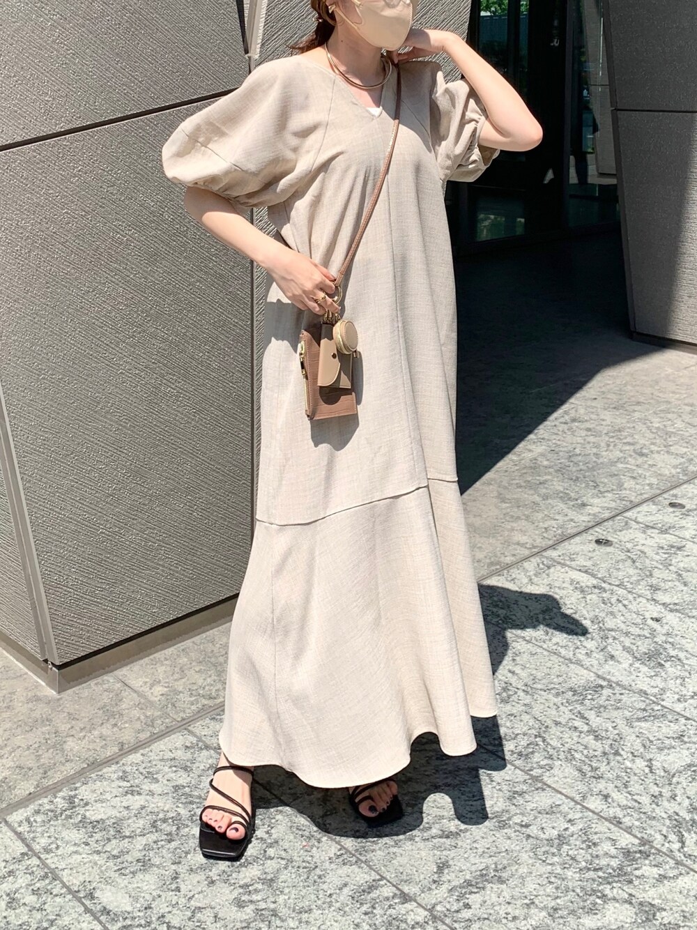 ベージュ系のワンピース、ブラウン系のショルダーバッグ、ブラック系のサンダルを着用したレディースの夏コーディネートの3枚目の写真