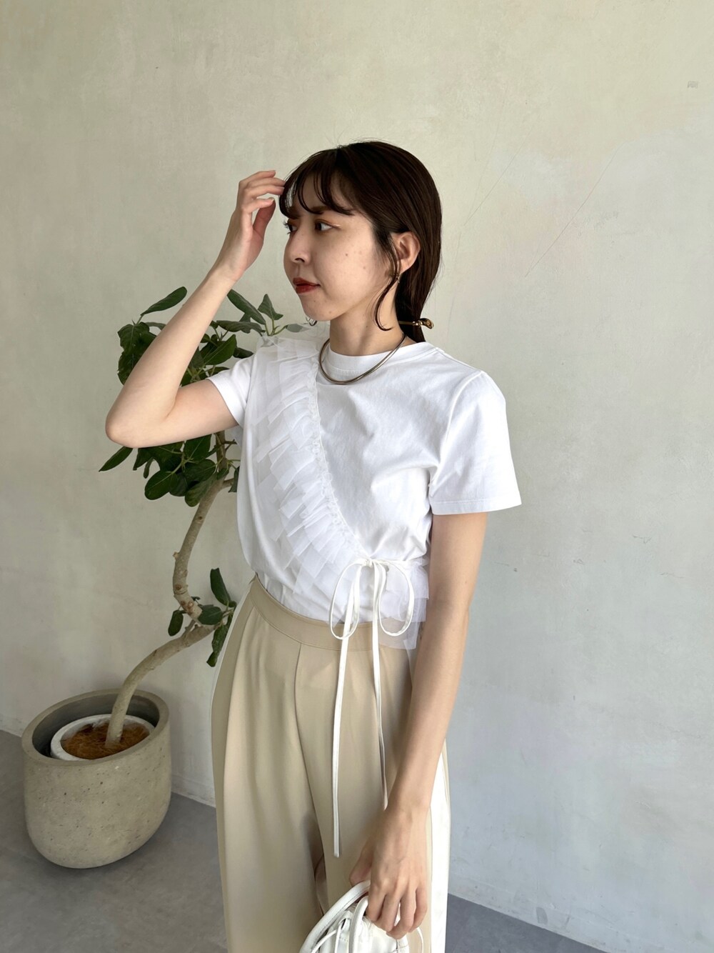 ホワイト系のTシャツ/カットソー、ベージュ系のその他パンツ、ホワイト系のショルダーバッグを着用したレディースの春コーディネートの3枚目の写真