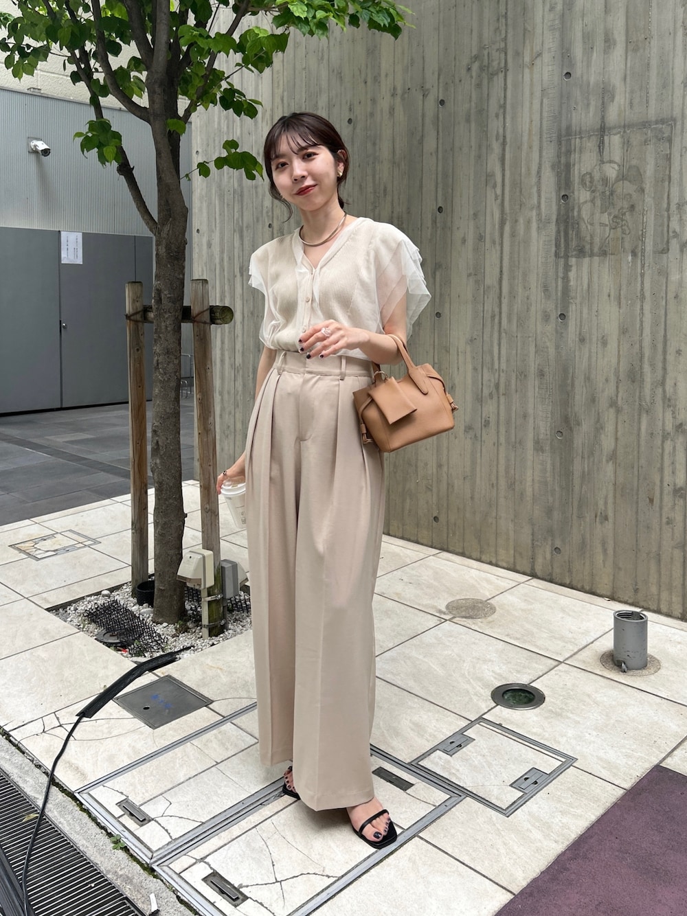 ベージュ系のニット/セーター、ベージュ系のその他パンツ、ブラック系のサンダルを着用したレディースの春コーディネートの1枚目の写真