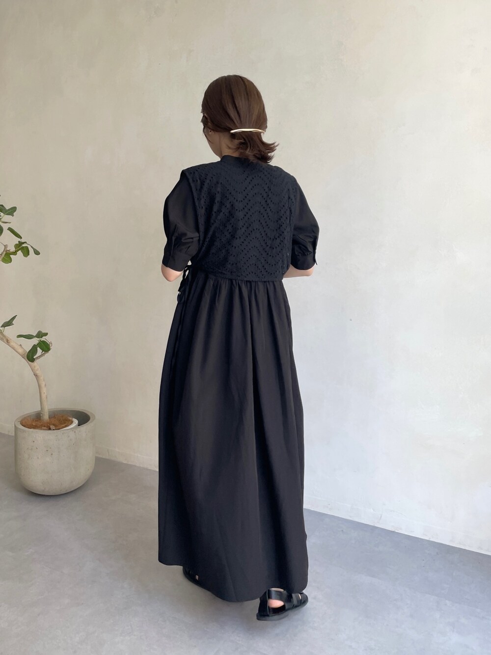 ブラック系のワンピース、オレンジ系のショルダーバッグ、ブラック系のサンダルを着用したレディースの夏コーディネートの3枚目の写真