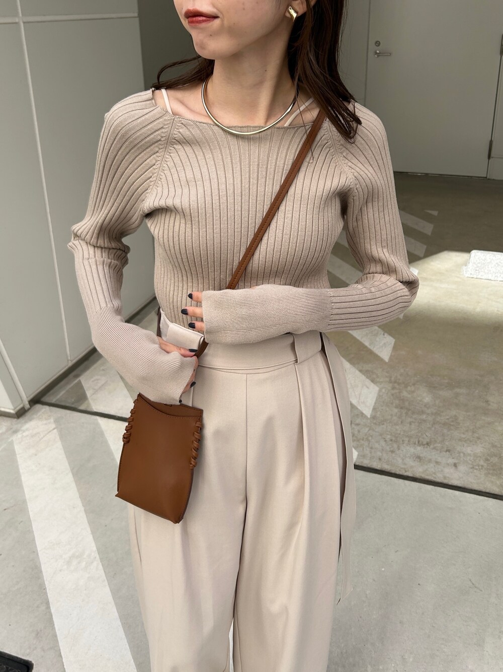 ベージュ系のニット/セーター、ホワイト系のその他パンツ、ブラウン系のハンドバッグを着用したレディースの秋コーディネートの3枚目の写真