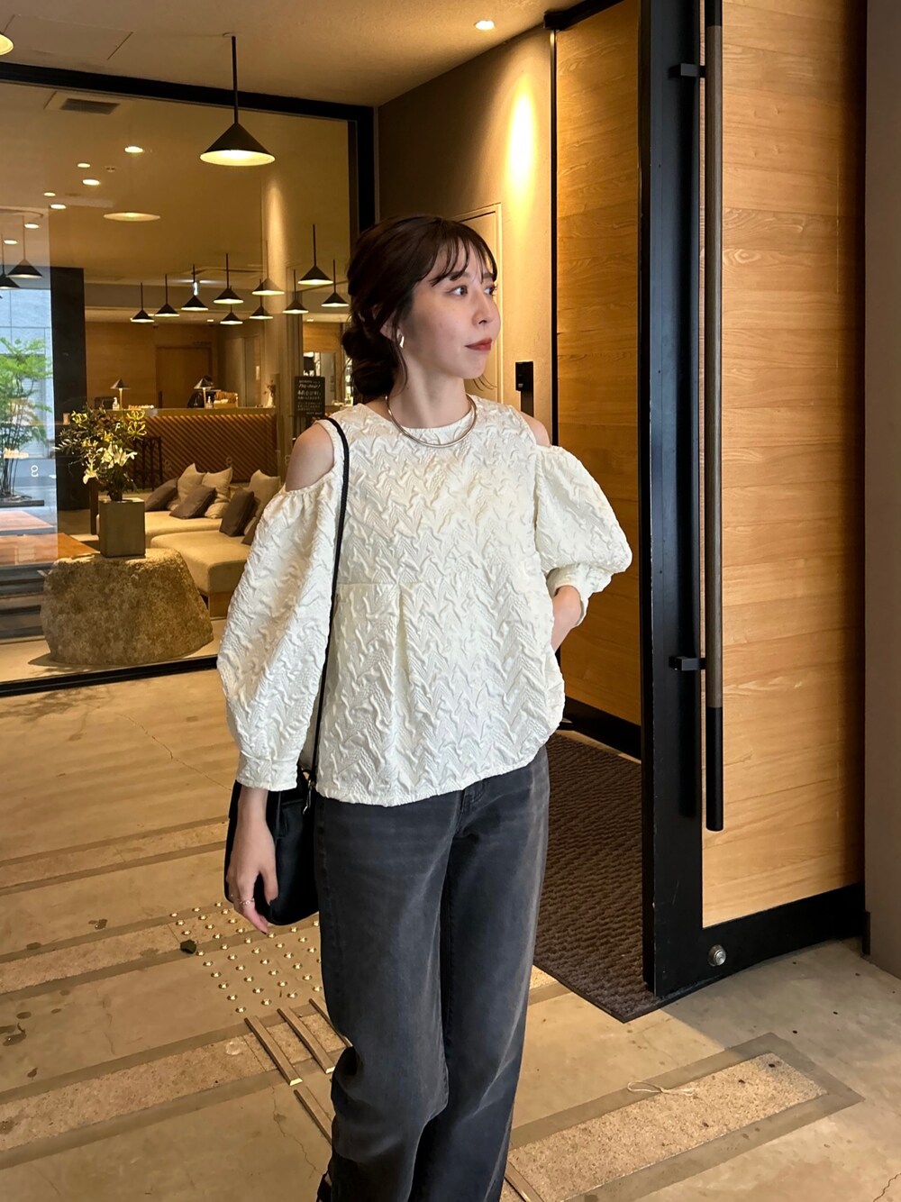 ホワイト系のシャツ/ブラウス、ブラック系のデニムパンツ、ブラック系のショルダーバッグを着用したレディースの春コーディネートの3枚目の写真