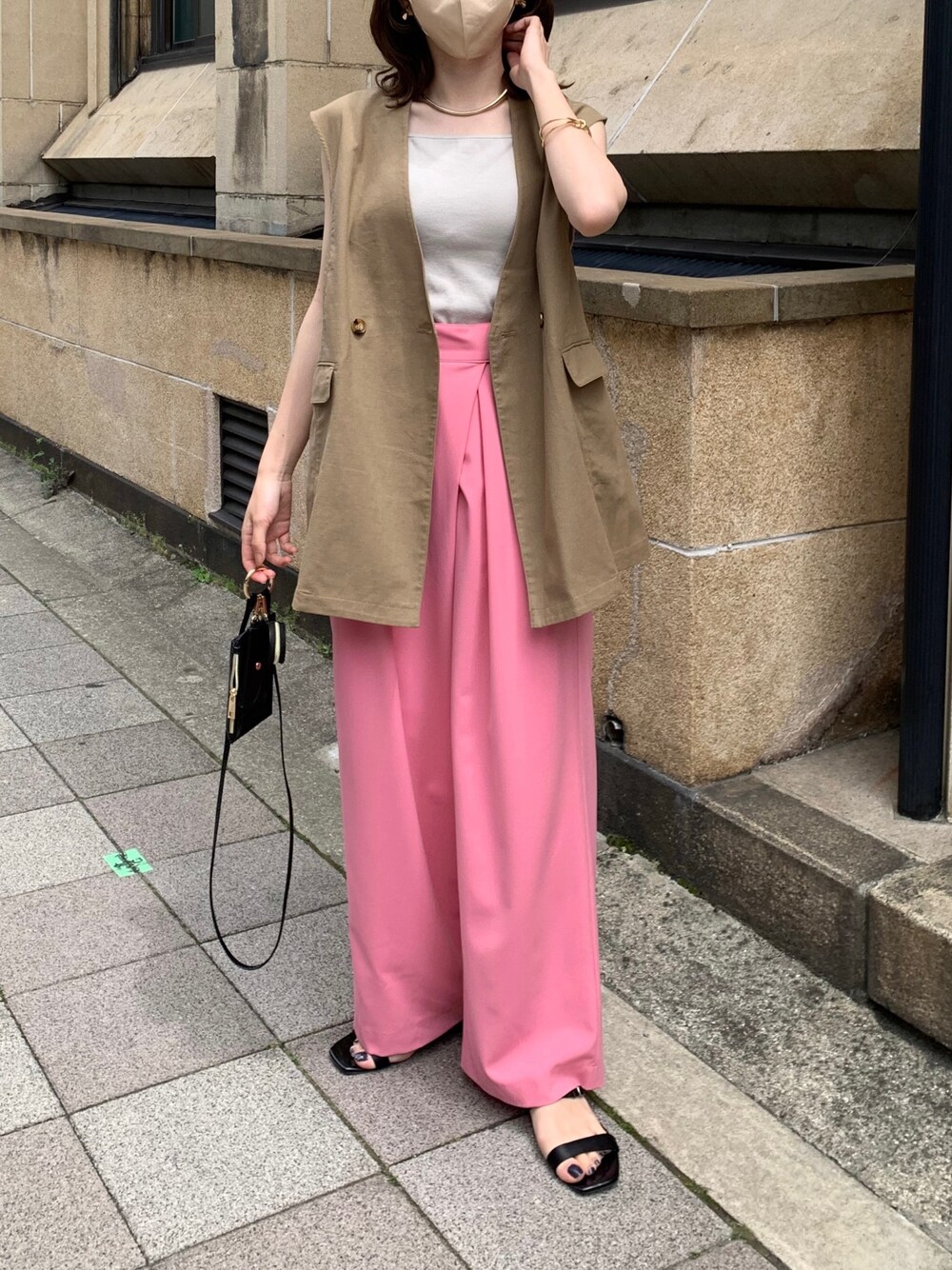 ブラウン系のベスト、ピンク系のその他パンツ、ブラック系のショルダーバッグを着用したレディースの春コーディネートの2枚目の写真