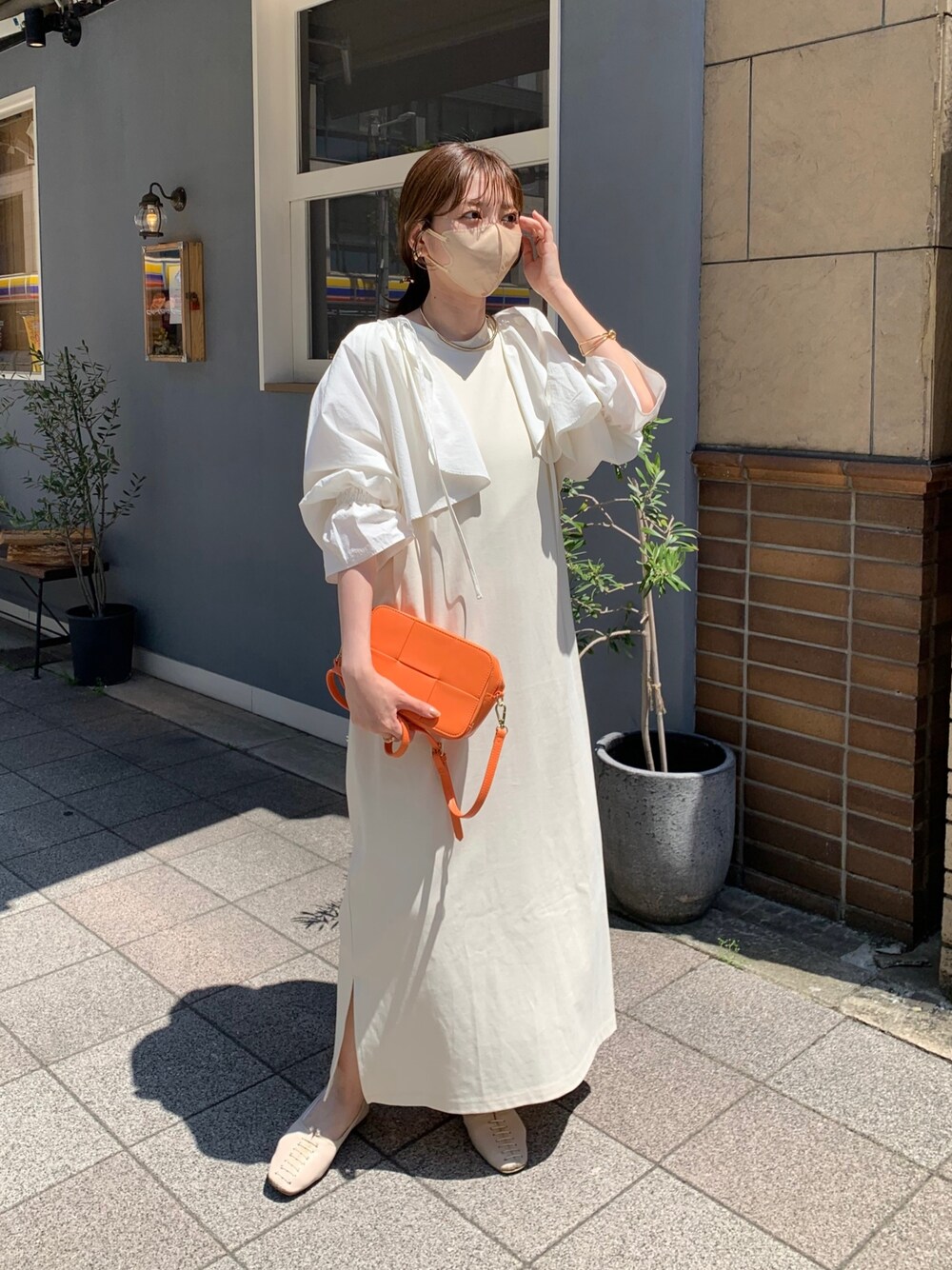 ホワイト系のシャツ/ブラウス、ホワイト系のワンピース、オレンジ系のショルダーバッグを着用したレディースの春コーディネートの2枚目の写真