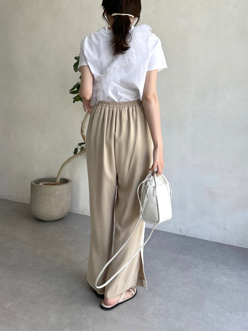 ホワイト系のTシャツ/カットソー、ベージュ系のその他パンツ、ホワイト系のショルダーバッグを着用したレディースの春コーディネートの2枚目の写真