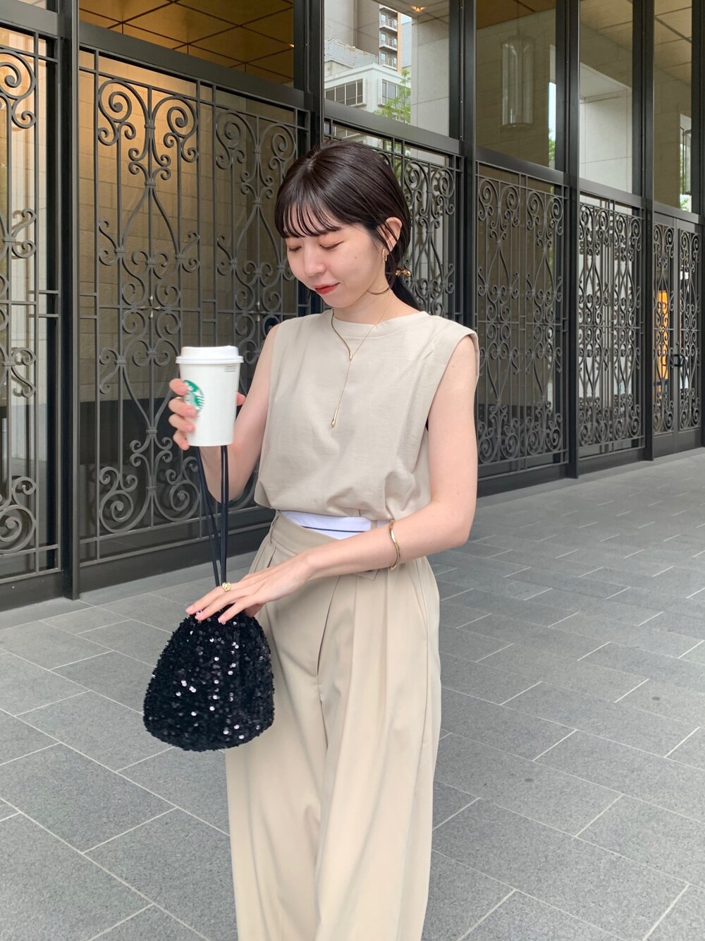 ベージュ系のTシャツ/カットソー、ブラック系のハンドバッグ、ベージュ系のその他パンツを着用したレディースの春コーディネートの2枚目の写真