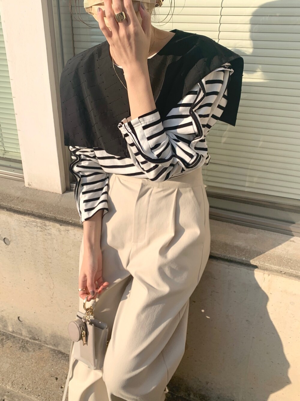 ブラック系のシャツ/ブラウス、ブラック系のTシャツ/カットソー、ベージュ系のショルダーバッグを着用したレディースの冬コーディネートの4枚目の写真