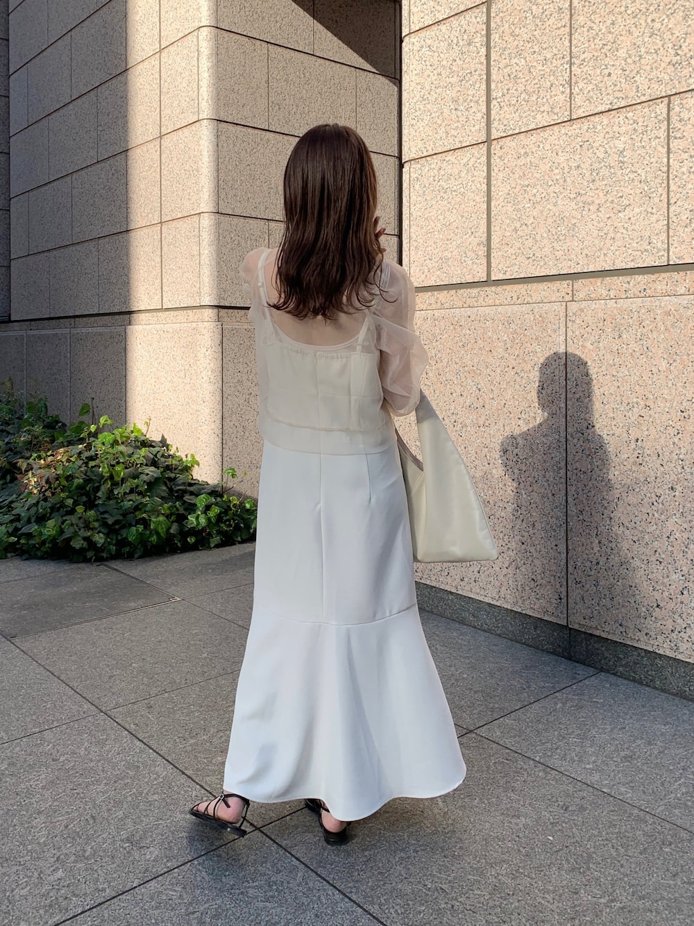 ベージュ系のシャツ/ブラウス、ブラック系のサンダル、ホワイト系のトートバッグを着用したレディースの春コーディネートの2枚目の写真