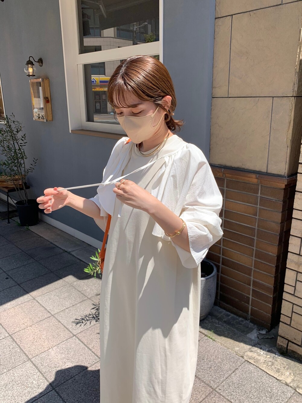 ホワイト系のシャツ/ブラウス、ホワイト系のワンピース、オレンジ系のショルダーバッグを着用したレディースの春コーディネートの4枚目の写真