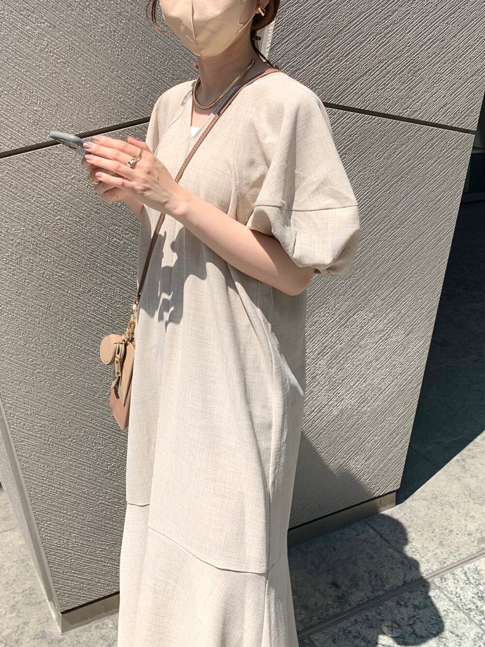 ベージュ系のワンピース、ブラウン系のショルダーバッグ、ブラック系のサンダルを着用したレディースの夏コーディネートの4枚目の写真