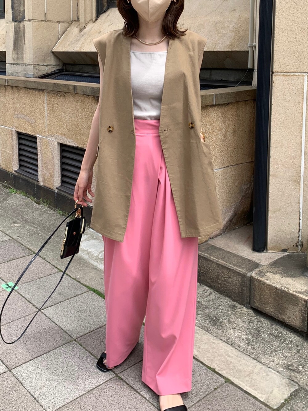 ブラウン系のベスト、ピンク系のその他パンツ、ブラック系のショルダーバッグを着用したレディースの春コーディネートの3枚目の写真