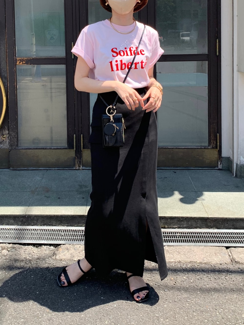 ピンク系のTシャツ/カットソー、ブラック系のショルダーバッグ、ブラック系のスカートを着用したレディースの春コーディネートの2枚目の写真