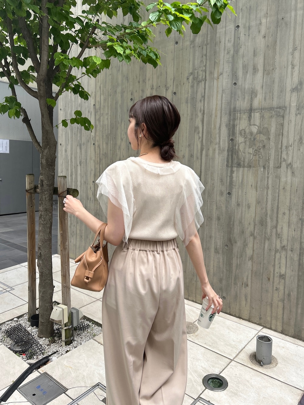 ベージュ系のニット/セーター、ベージュ系のその他パンツ、ブラック系のサンダルを着用したレディースの春コーディネートの3枚目の写真