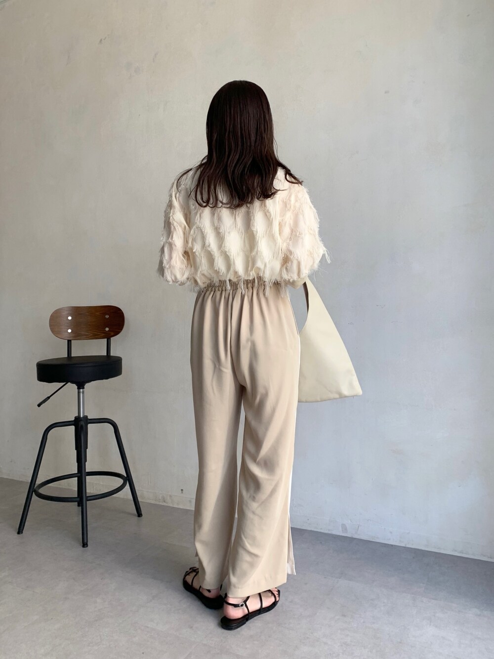 ホワイト系のシャツ/ブラウス、ベージュ系のその他パンツ、ホワイト系のトートバッグを着用したレディースの春コーディネートの2枚目の写真