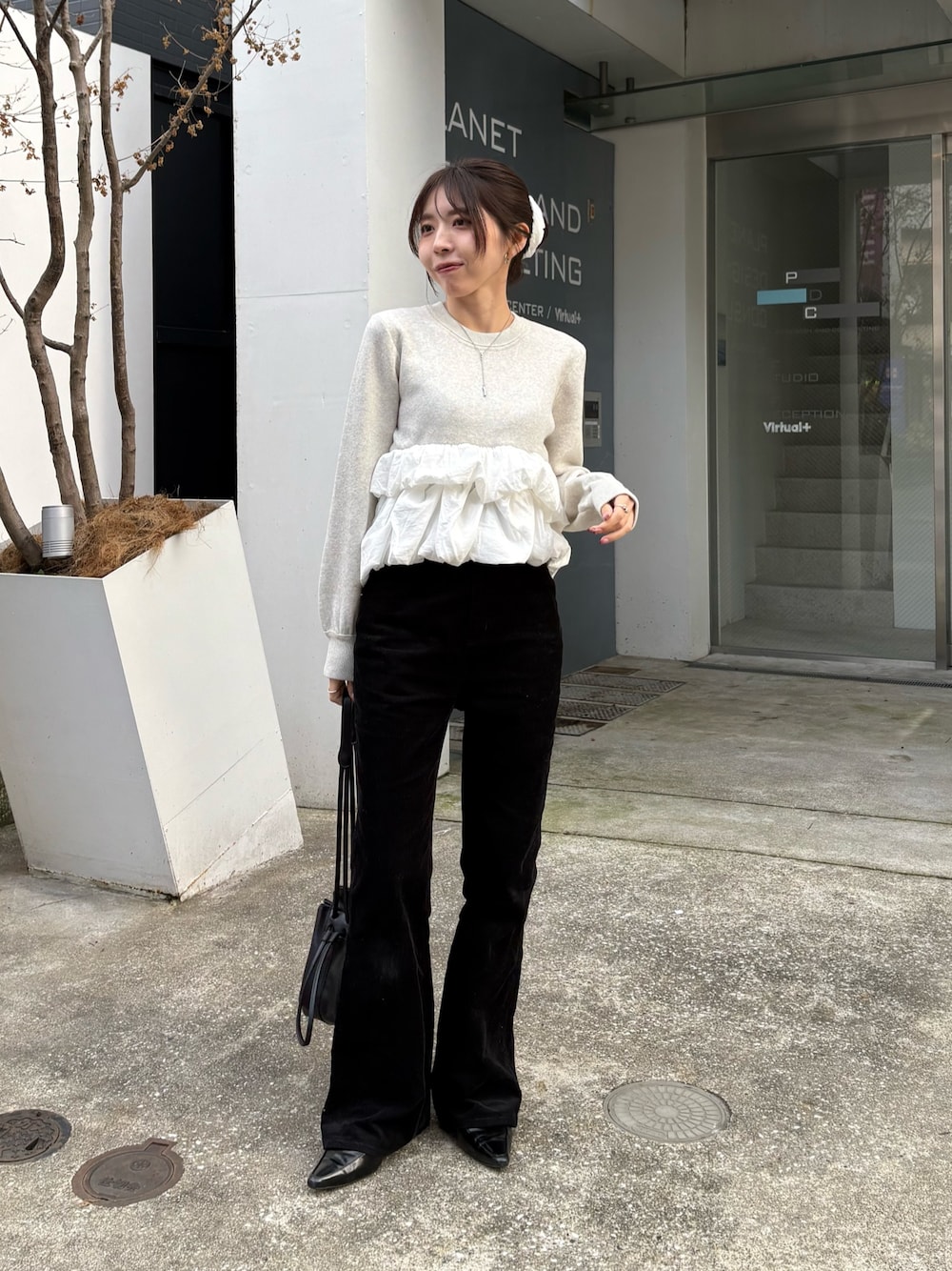 グレー系のニット/セーター、ブラック系のその他パンツ、ブラック系のショルダーバッグを着用したレディースの秋コーディネートの1枚目の写真