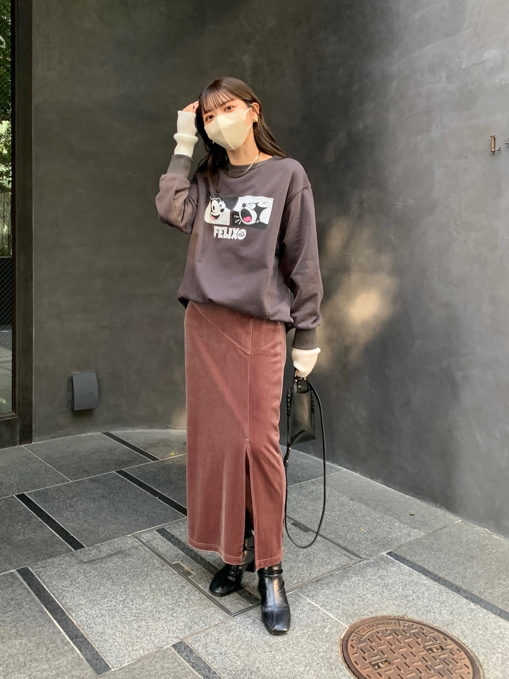 グレー系のTシャツ/カットソー、ブラック系のハンドバッグ、ブラウン系のスカートを着用したレディースの秋コーディネートの1枚目の写真