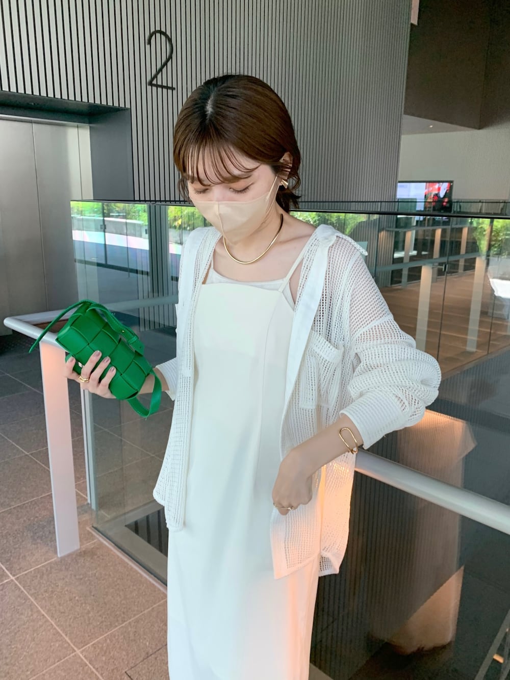 ホワイト系のワンピース、グリーン系のボディバッグ/ウエストポーチ、ホワイト系のシャツ/ブラウスを着用したレディースの夏コーディネートの3枚目の写真
