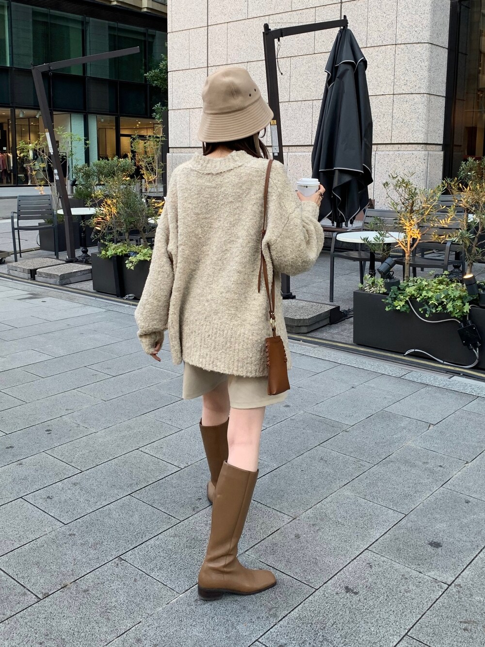 ホワイト系のその他パンツ、ベージュ系のニット/セーター、ブラウン系のブーツを着用したレディースの秋コーディネートの2枚目の写真