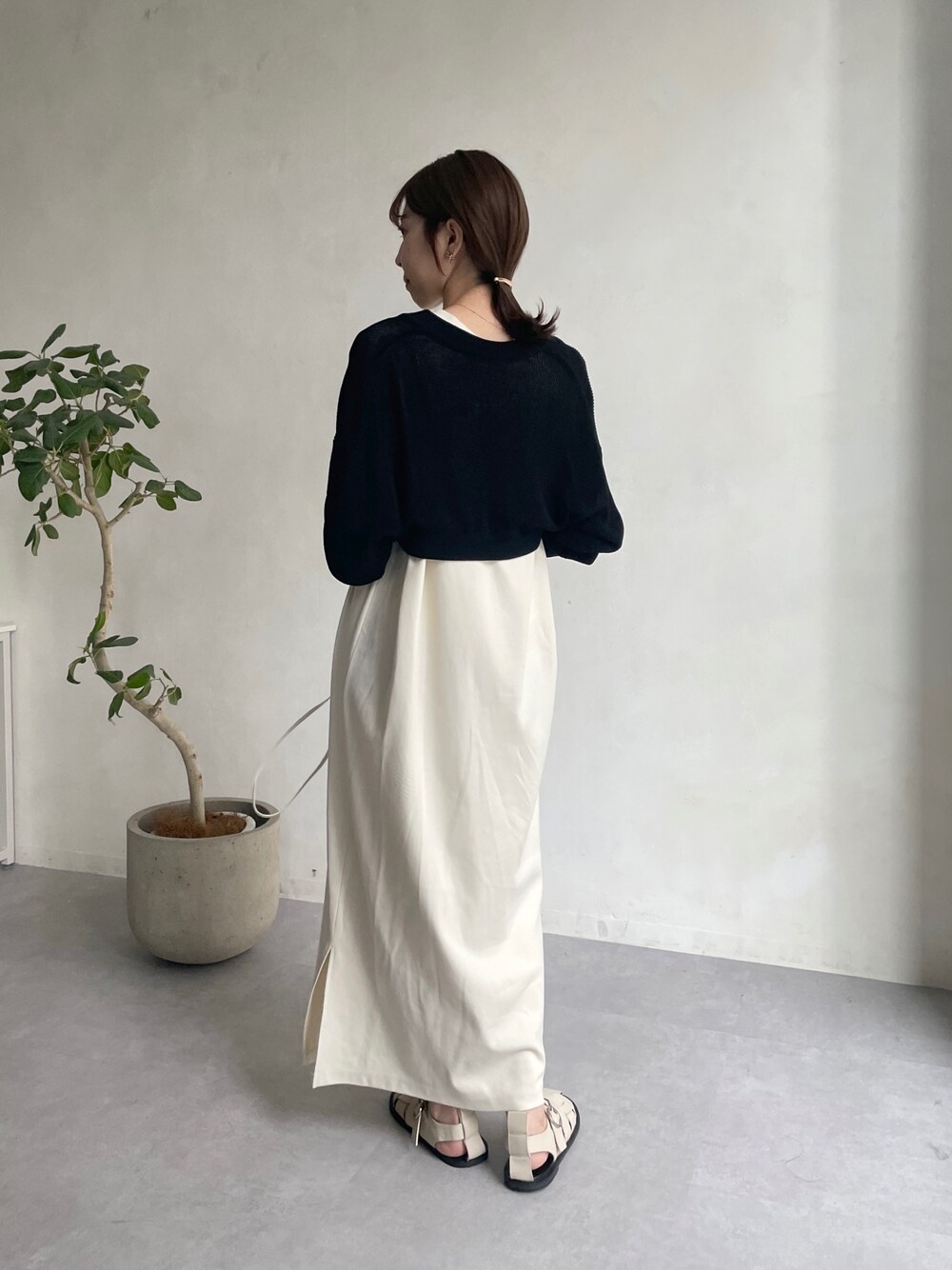 ブラック系のカーディガン/ボレロ、ホワイト系のワンピース、ホワイト系のサンダルを着用したレディースの夏コーディネートの2枚目の写真