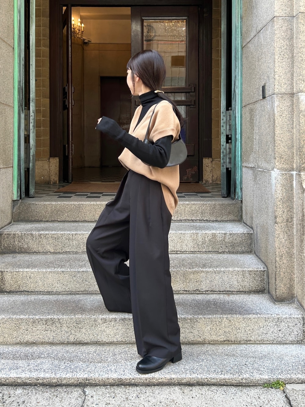 ブラック系のその他パンツ、ブラック系のニット/セーター、ベージュ系のベストを着用したレディースの秋コーディネートの2枚目の写真