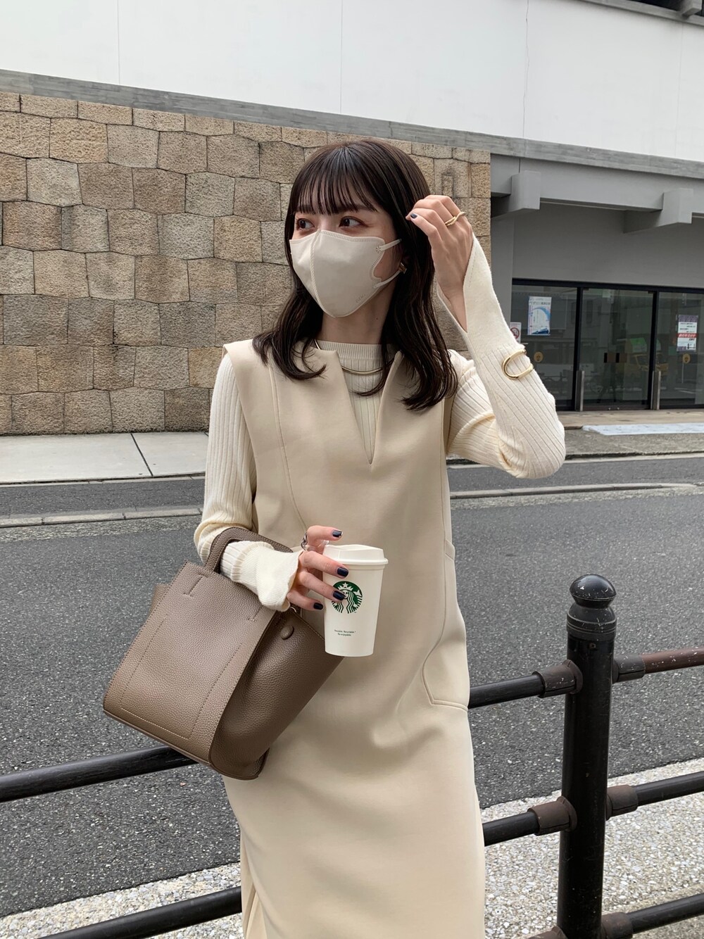 ベージュ系のワンピース、ホワイト系のニット/セーター、ブラウン系のブーツを着用したレディースの秋コーディネートの3枚目の写真