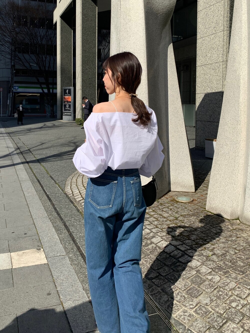 ホワイト系のシャツ/ブラウス、ブラック系のハンドバッグ、ブラック系のサンダルを着用したレディースの春コーディネートの3枚目の写真