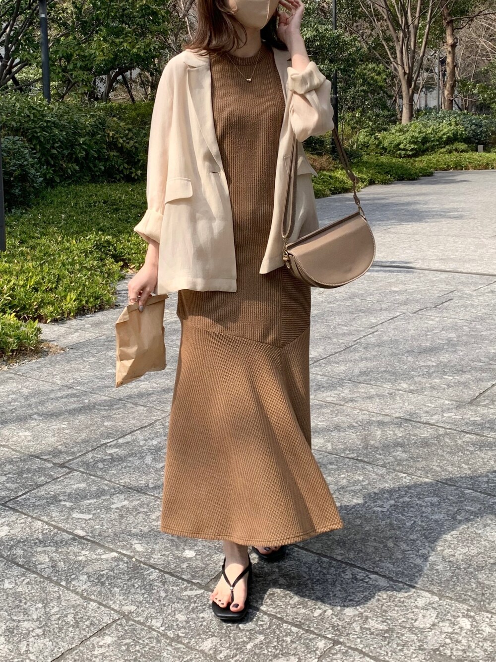 ベージュ系のテーラードジャケット、ブラウン系のワンピース、ブラック系のその他シューズを着用したレディースの春コーディネートの3枚目の写真