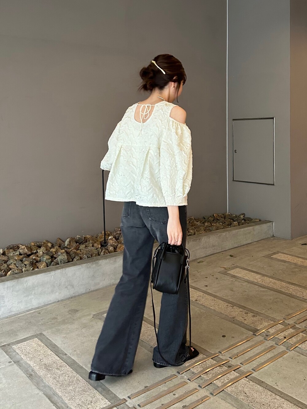 ホワイト系のシャツ/ブラウス、ブラック系のデニムパンツ、ブラック系のショルダーバッグを着用したレディースの春コーディネートの2枚目の写真