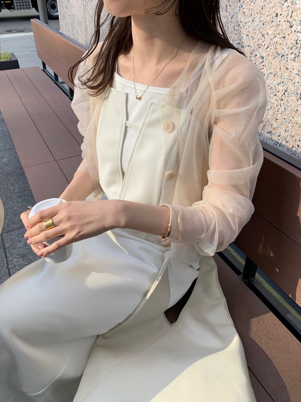 ベージュ系のシャツ/ブラウス、ブラック系のサンダル、ホワイト系のトートバッグを着用したレディースの春コーディネートの3枚目の写真