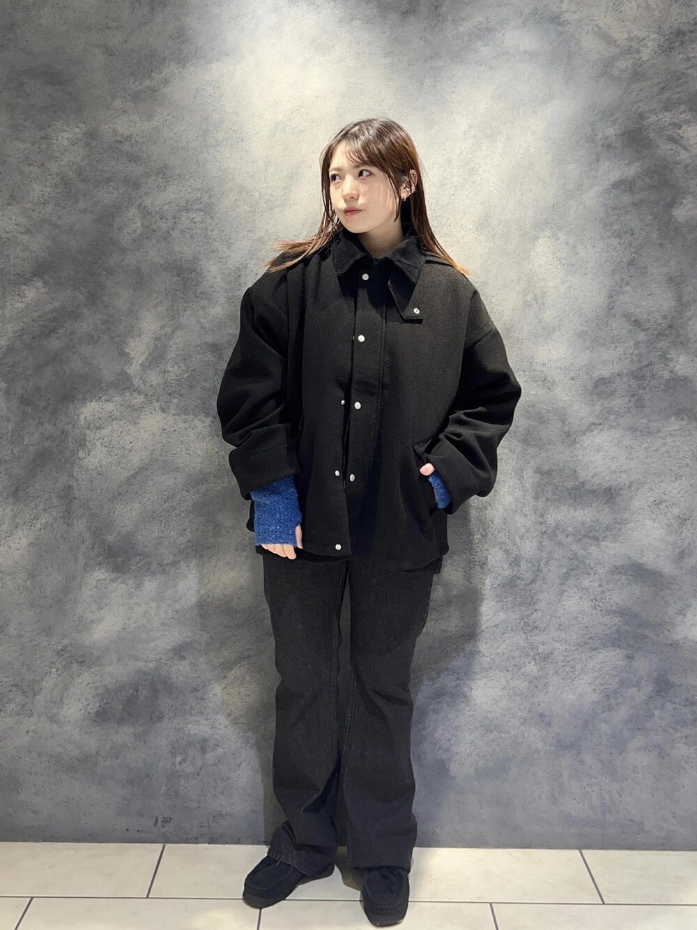 ブラック系のデニムパンツ、ブラック系のニット/セーター、ブラック系のブルゾンを着用したレディースの秋コーディネートの1枚目の写真