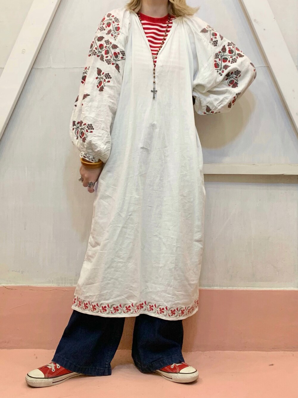 レッド系のスニーカーを着用したレディースの秋コーディネートの1枚目の写真