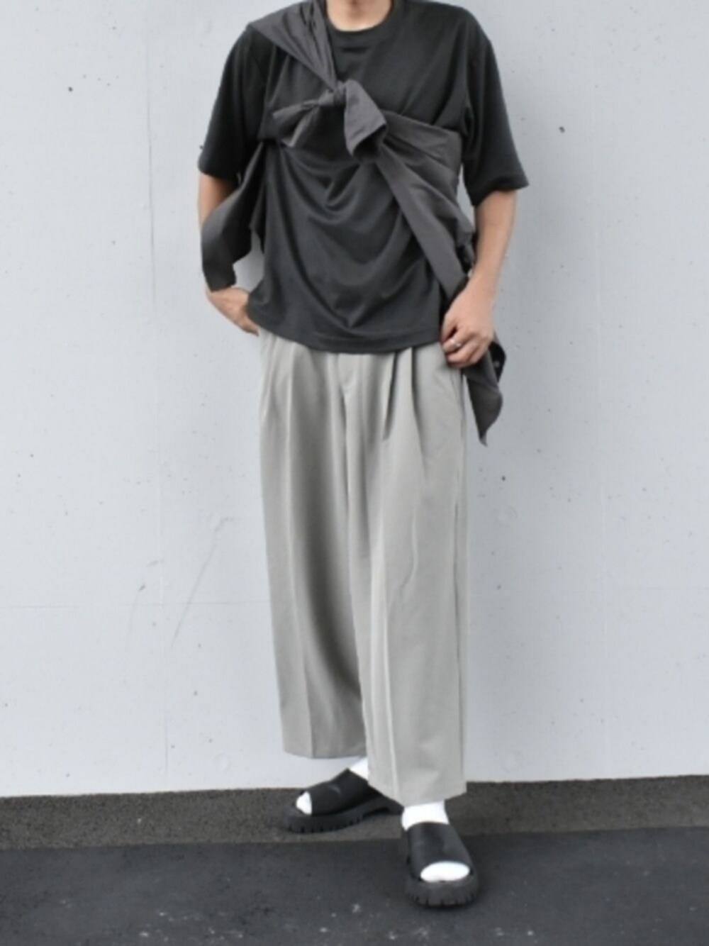 その他のTシャツ/カットソー、グレー系のスラックス、ブラック系のサンダルを着用したメンズの夏コーディネートの1枚目の写真