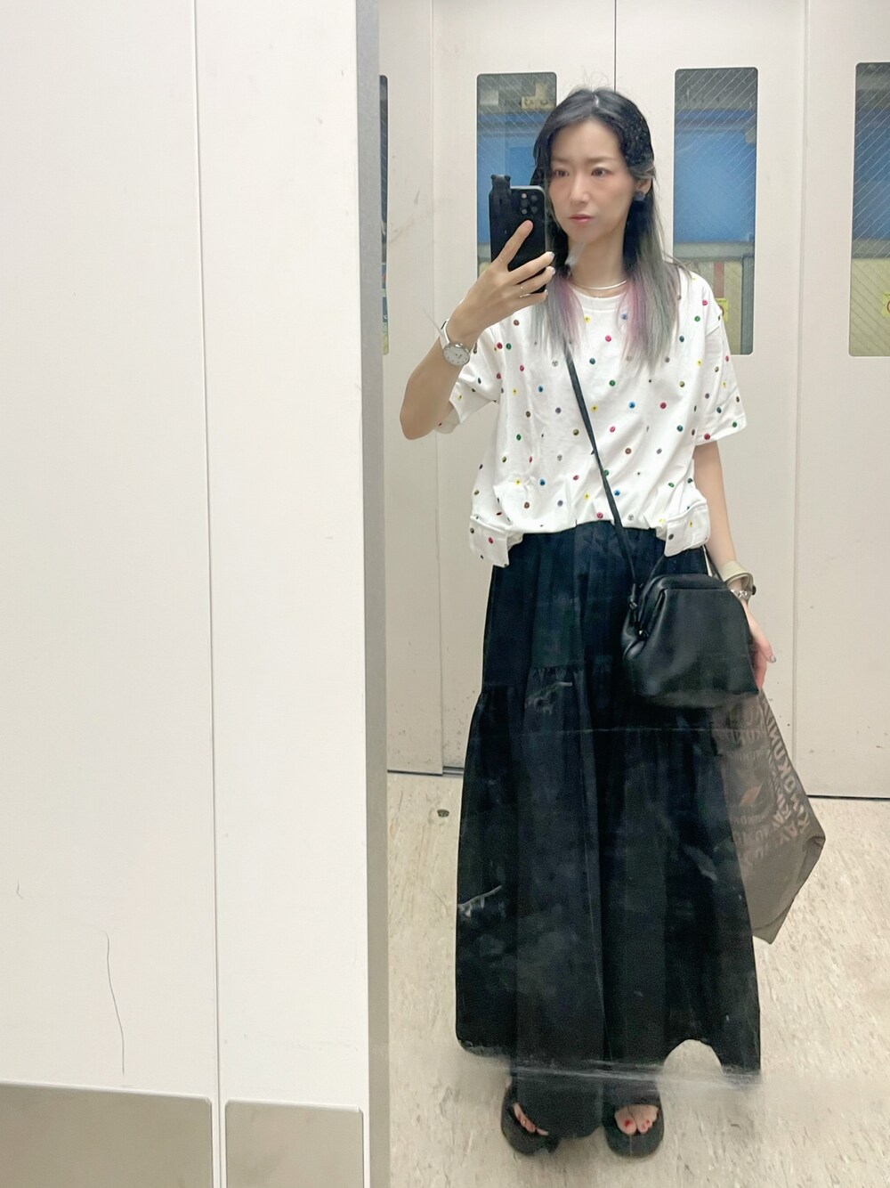 ブラック系のスカート、ホワイト系のTシャツ/カットソー、ブラック系のショルダーバッグを着用したレディースの夏コーディネートの1枚目の写真