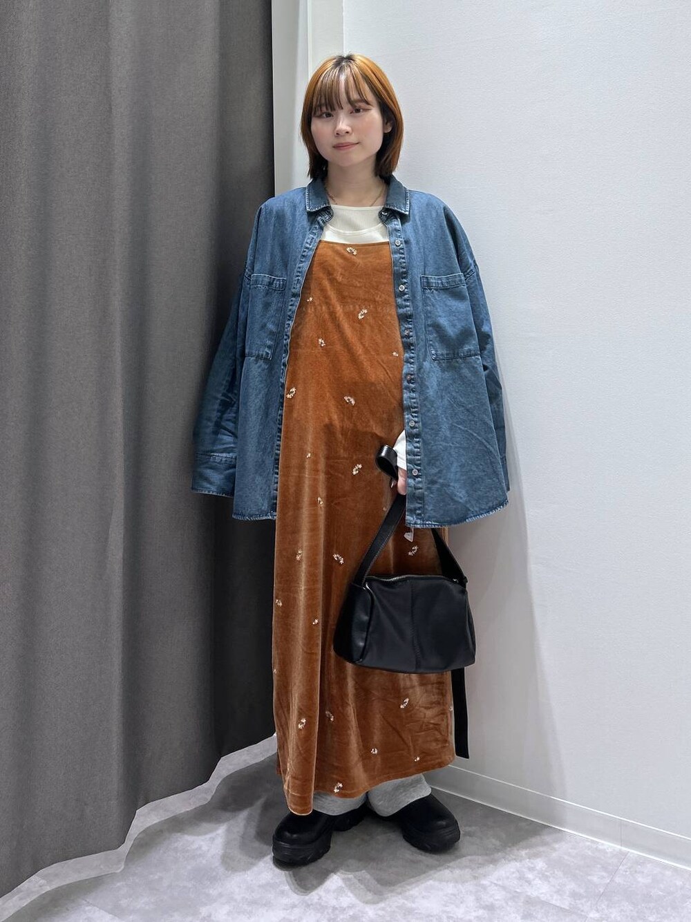 ブルー系のシャツ/ブラウス、ブラック系のショルダーバッグ、グレー系のスウェットパンツを着用したレディースの秋コーディネートの1枚目の写真