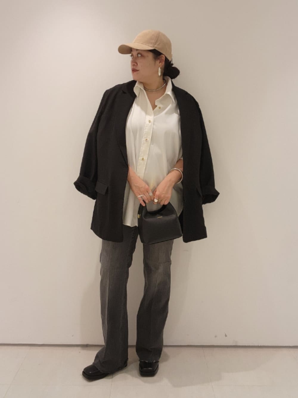 ブラック系のベスト、ホワイト系のシャツ/ブラウス、ブラック系のデニムパンツを着用したレディースの秋コーディネートの1枚目の写真