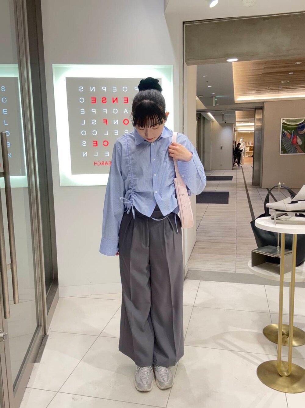 ピンク系のショルダーバッグ、グレー系のその他パンツ、ブルー系のシャツ/ブラウスを着用したレディースの春コーディネートの1枚目の写真