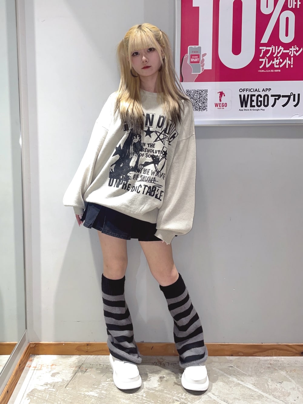 ブラック系のデニムスカート、ベージュ系のニット/セーター、ホワイト系のスニーカーを着用したレディースの秋コーディネートの1枚目の写真