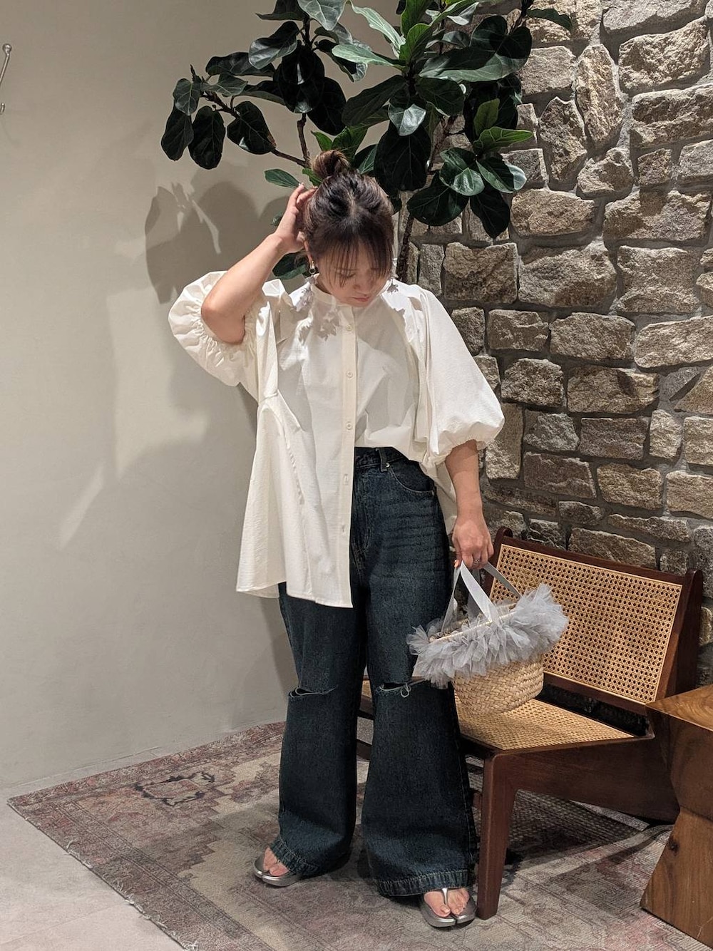 シルバー系のサンダル、グレー系のかごバッグ、ブルー系のデニムパンツを着用したレディースの春コーディネートの1枚目の写真
