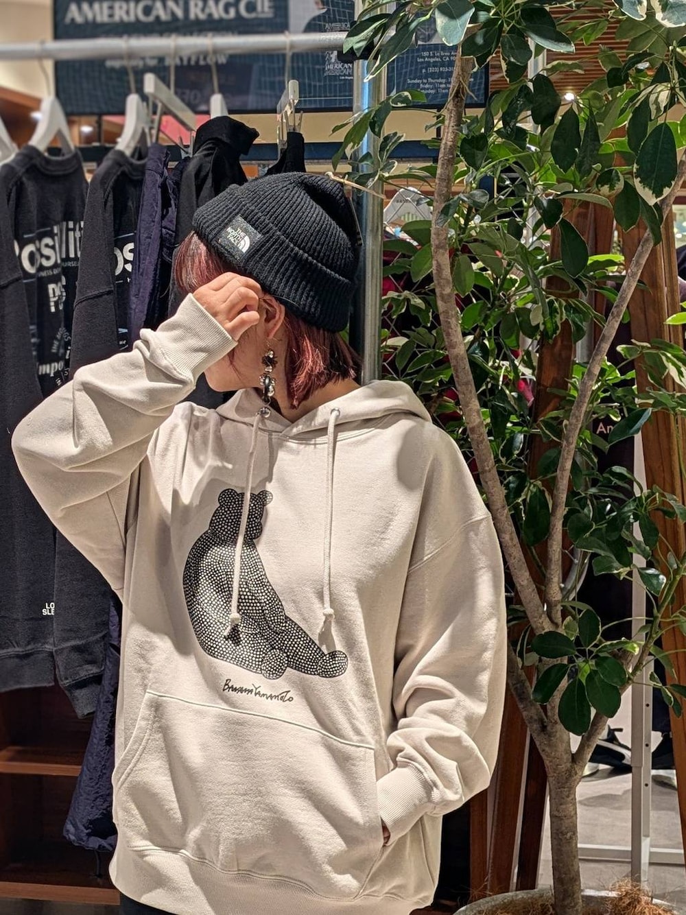 ピンク系のスニーカー、ブラック系のスカート、グレー系のパーカーを着用したレディースの秋コーディネートの1枚目の写真