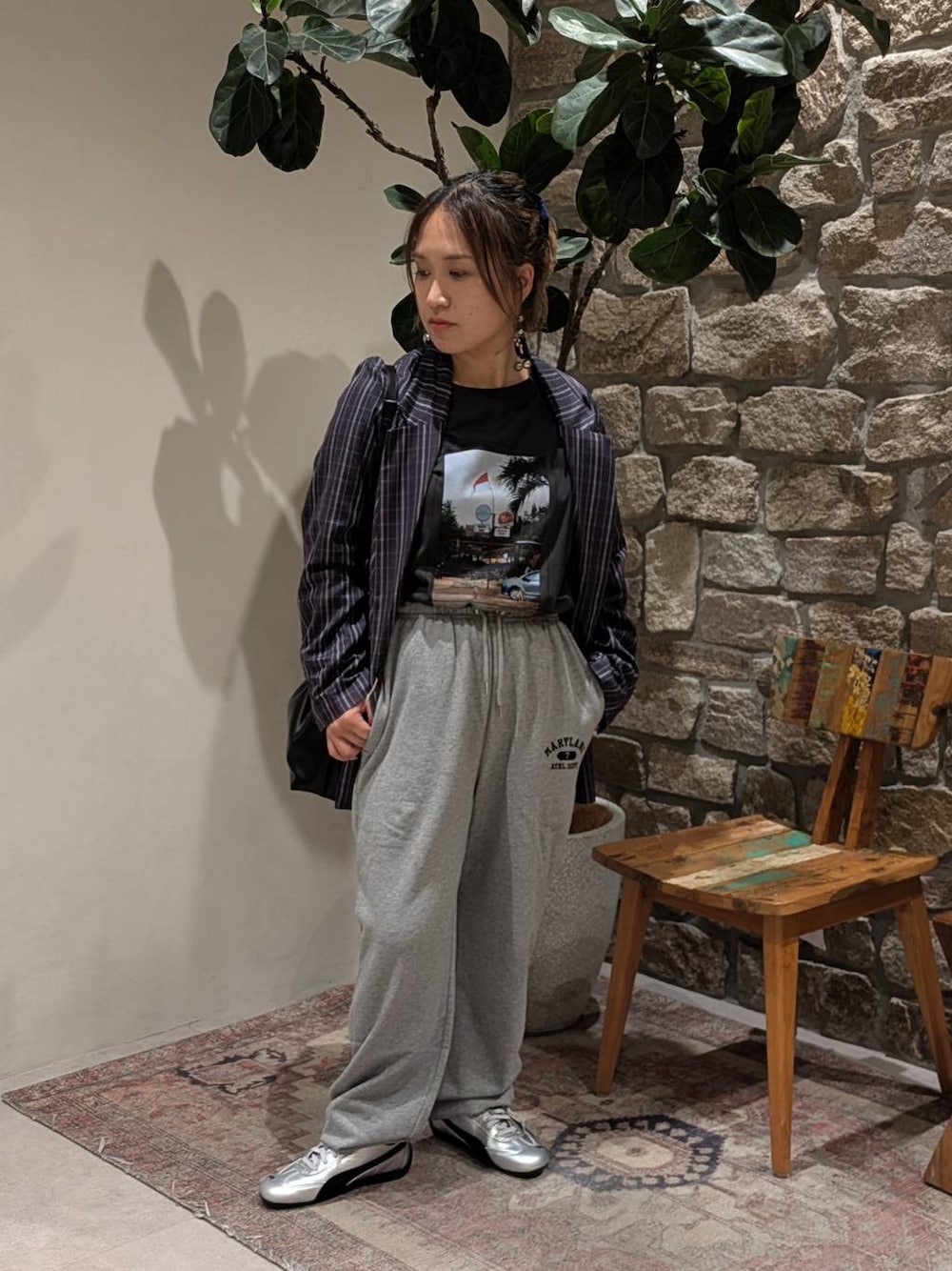 グレー系のスニーカー、グレー系のスウェットパンツ、ブラック系のハンドバッグを着用したレディースの秋コーディネートの1枚目の写真